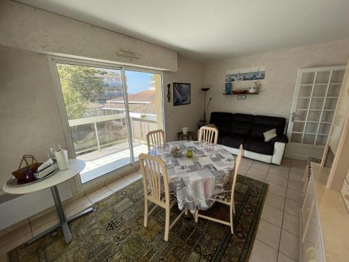 un salon avec une table, des chaises et un canapé dans l'établissement Appartement T3 à Arcachon avec balcon - 4 couchages, proche plage, tout équipé - FR-1-474-202, à Arcachon