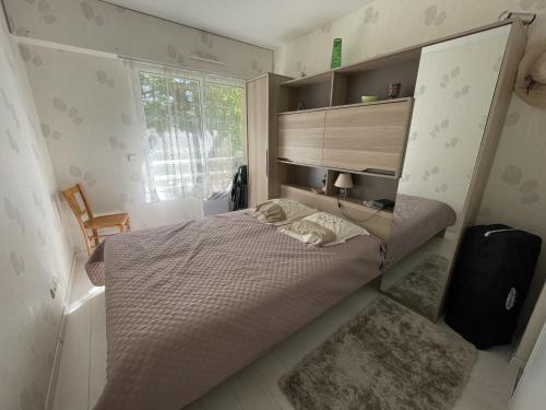 une petite chambre avec un lit et une fenêtre dans l'établissement Appartement T3 à Arcachon avec balcon - 4 couchages, proche plage, tout équipé - FR-1-474-202, à Arcachon