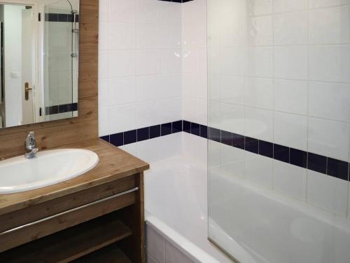 une salle de bain avec un lavabo et une baignoire dans l'établissement Appartement skis aux pieds avec piscine intérieure, proche services - FR-1-322-478, aux Orres
