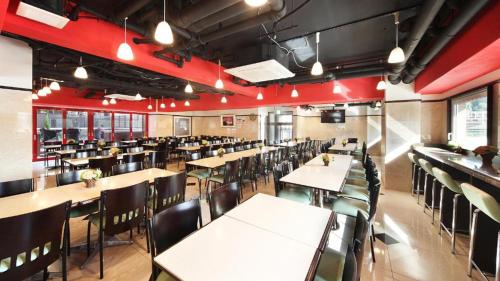 um restaurante com mesas e cadeiras e paredes vermelhas em Toyoko Inn Osaka Abeno Tennoji em Osaka