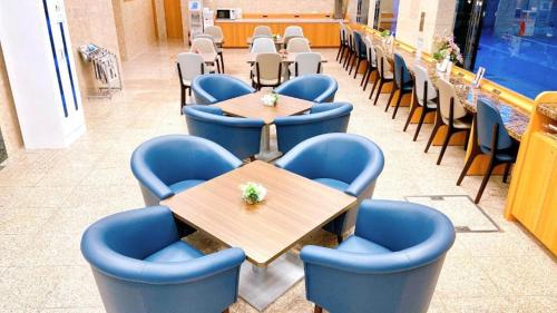 a dining room with blue chairs and tables in a restaurant at Toyoko Inn Osaka Umeda Nakatsu No.1 in Osaka