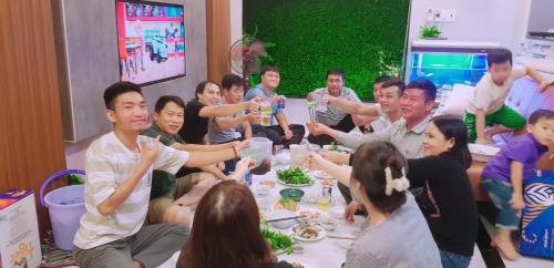 a group of people sitting around a table eating at Triple-T Homestay in Vung Tau