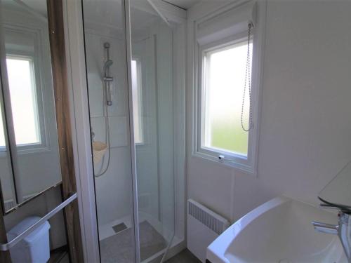 baño blanco con ducha y lavamanos en Chalet Dolus-d'Oléron, 3 pièces, 4 personnes - FR-1-246A-120, en Dolus d'Oléron