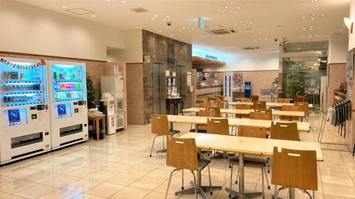 un restaurante con mesas y sillas y máquinas expendedoras. en Toyoko Inn Osaka Umeda Higashi, en Osaka