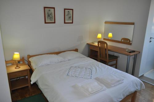 Una cama o camas en una habitación de APARTMANI PERGOLO Centar