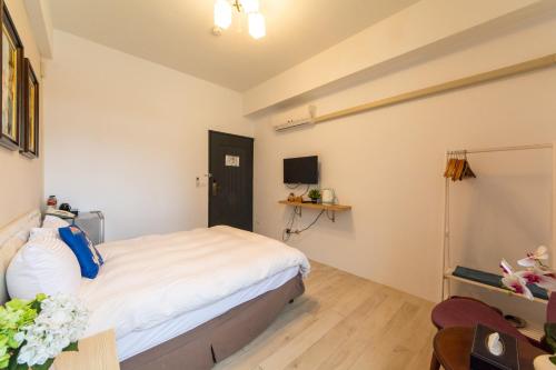 a bedroom with a bed and a desk and a table at Jinguann B&B in Hualien City
