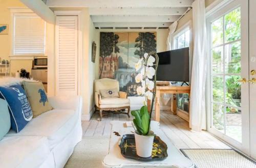 a living room with a white couch and a tv at Chateau Gardens in Lake Worth