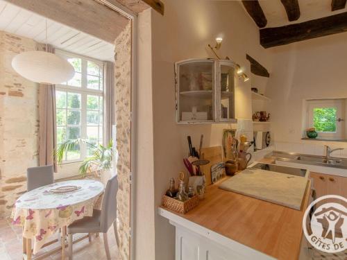 una cucina con un tavolo e un piano di lavoro di Charmant gîte familial avec parc, près des vignobles, à 30 min d’Angers - Confort et cadre raffiné. - FR-1-622-34 a Rochefort-sur-Loire