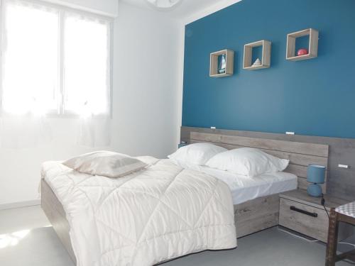 - une chambre dotée d'un lit avec un mur bleu dans l'établissement Maison Sarzeau, 4 pièces, 6 personnes - FR-1-639-53, à Sarzeau