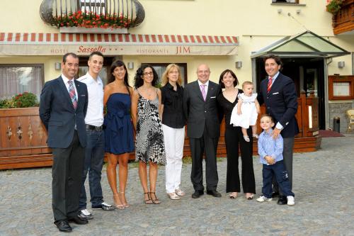 a family posing for a picture in front of a building at Hotel Sassella in Grosio
