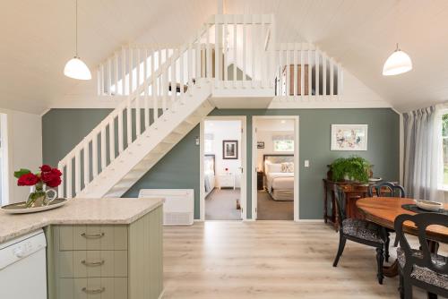 eine Küche und ein Esszimmer mit einer Treppe in einem Haus in der Unterkunft Arcadia Lodge Russell in Russell
