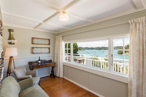 a living room with a large window and a view of the water at Arcadia Lodge Russell in Russell