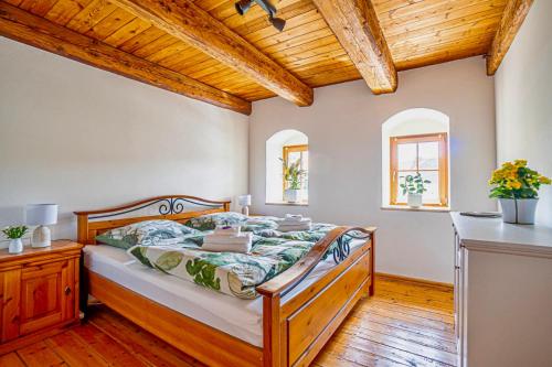 a bedroom with a bed and a wooden ceiling at Living in the old granary in Ermsleben