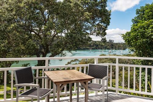 a table and chairs on a balcony with a view of the water at Arcadia Lodge Russell in Russell