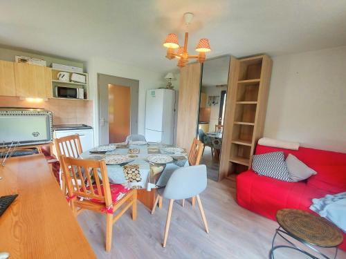 une cuisine et un salon avec une table et des chaises dans l'établissement Cosy appartement au centre de Morillon, proche télécabine, balcon et parking - FR-1-624-104, à Morillon