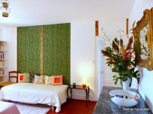 1 dormitorio con 2 camas y pared verde en Gîte Lurcy-Lévis, 2 pièces, 3 personnes - FR-1-489-376, en Lurcy-Lévis