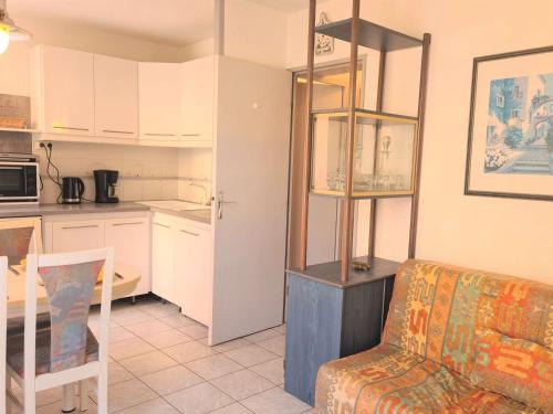un salon avec un canapé et une cuisine dans l'établissement Appartement RDC avec Jardin, Proche Plage - 4 Couchages, Cap d'Agde - FR-1-249-374, au Cap d'Agde
