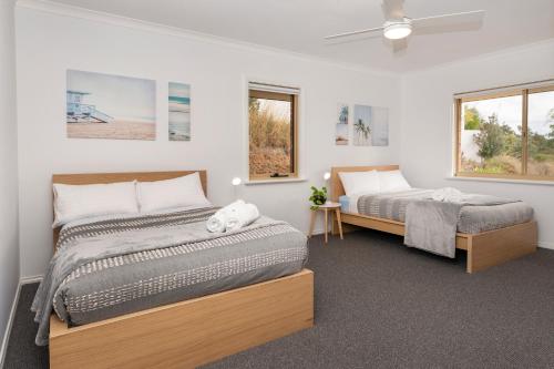 a bedroom with two beds and two windows at Gypsy Rise in Dunsborough
