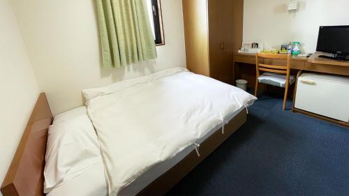ein Krankenhauszimmer mit einem Bett und einem Schreibtisch in der Unterkunft Business Hotel Rupinasu in Takamatsu