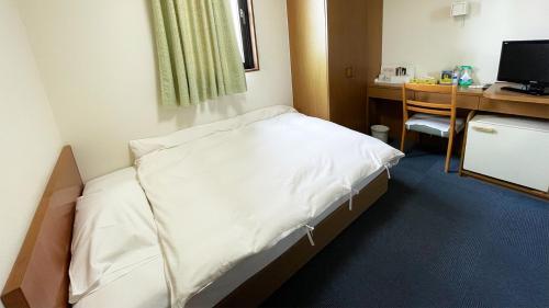 a hospital room with a bed and a desk at Business Hotel Rupinasu in Takamatsu