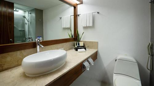 a bathroom with a white sink and a toilet at Marco Polo Plaza Cebu in Cebu City