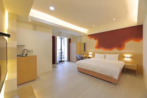 um quarto de hotel com uma cama e uma cozinha em Donghao Hotel em Yuli