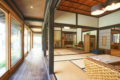 a living room with wooden floors and large windows at せとうち母家 Setouchi OMOYA in Fukuyama