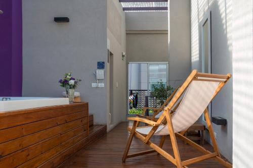 a wooden rocking chair in a bathroom with a tub at Infinito Hotel in Buenos Aires