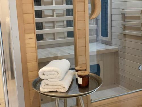 a glass table with towels on it in a shower at Kuh Blick Ferienhaus Sehestedt in Sehestedt