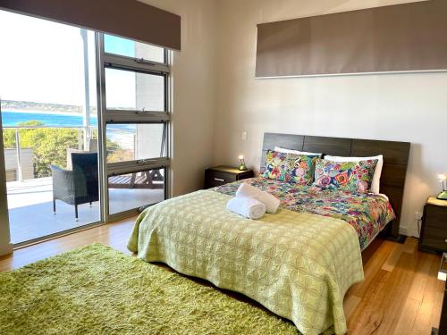 a bedroom with a bed and a large window at Annies View in Emu Bay