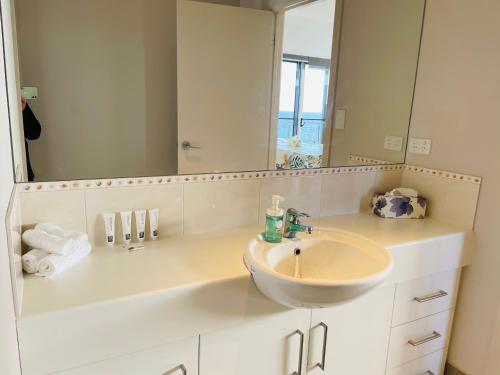 a white bathroom with a sink and a mirror at Annies View in Emu Bay