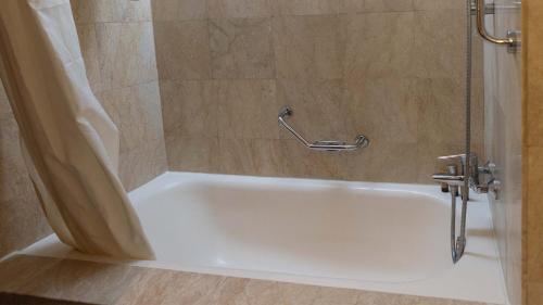 a white bath tub in a bathroom with a shower at Marco Polo Plaza Cebu in Cebu City