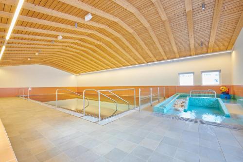 a pool in a room with a wooden ceiling at Reka-Feriendorf Bergün in Bergün