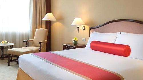 a hotel room with a bed and a chair at Marco Polo Plaza Cebu in Cebu City