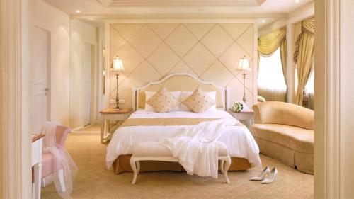 a bedroom with a large white bed and a chair at Marco Polo Plaza Cebu in Cebu City