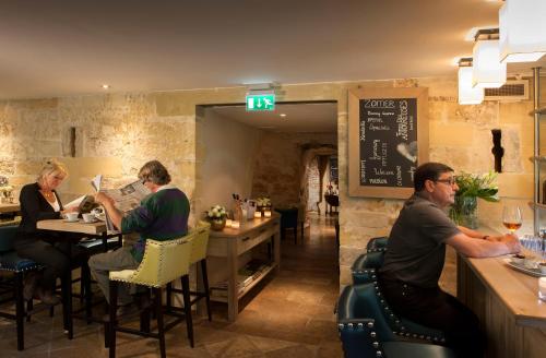 a group of people sitting at a bar in a restaurant at Van der Valk Hotel Kasteel Terworm in Heerlen
