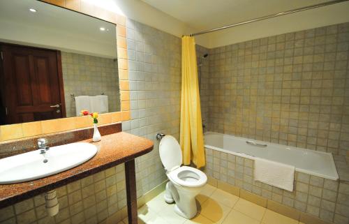 a bathroom with a sink and a toilet and a tub at Speke Hotel 1996 Ltd in Kampala