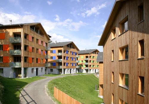 a row of apartment buildings next to a road at Reka-Feriendorf Disentis in Disentis