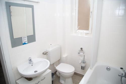 a white bathroom with a toilet and a sink at Othman Appartements Falkenstraße 26 3OG L in Hannover