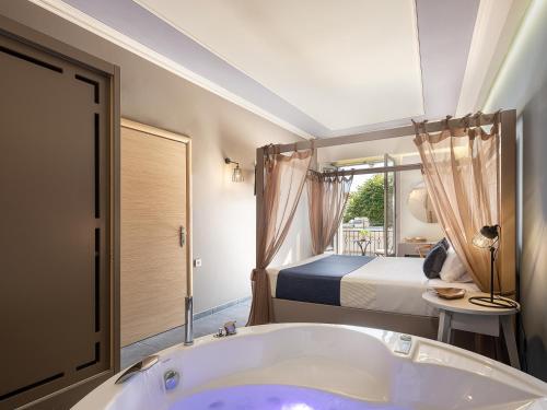 un bagno con vasca e una camera con letto di Elia Potie a Chania