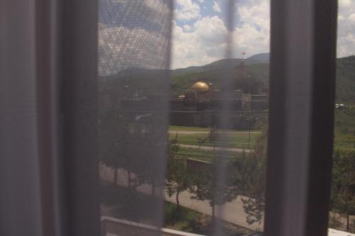 a window with a view of a field and mountains at Hotel Rabati in Akhaltsikhe