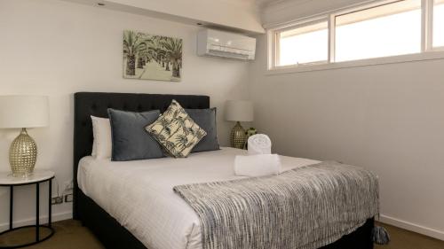 a bedroom with a bed and two windows at Brighton House in Melbourne