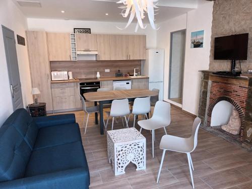 un salon avec un canapé bleu, une table et des chaises dans l'établissement AZUREO - Terrasse du golfe, à Morsiglia