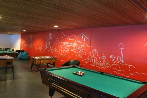 a room with a pool table in front of a wall at Reka-Feriendorf Disentis in Disentis