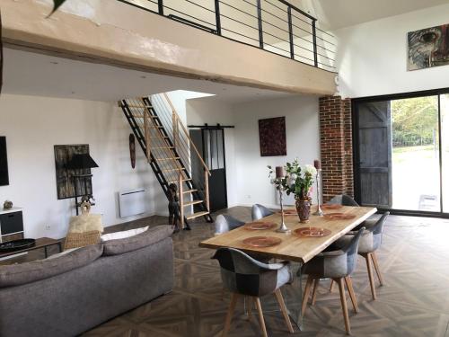 a dining room with a wooden table and chairs at Gîte dans un Haras in Émanville