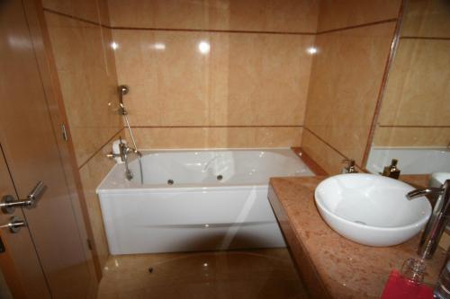 bagno con vasca bianca e lavandino di Hotel Soltroia - Foz Do Sado a Tróia