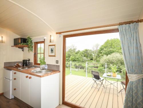 a kitchen with a sliding glass door to a deck at Llety'r Bugail 2 in Caernarfon