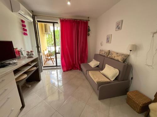a living room with a couch and a red curtain at Horizon Apartament Gut in Sveti Vlas