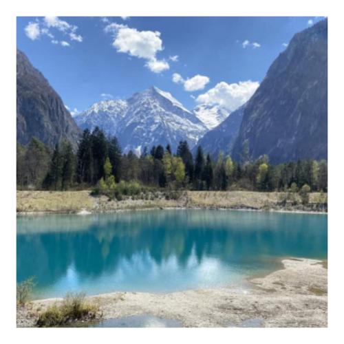 a large blue lake with mountains in the background at L'émeraude in Le Bourg-dʼOisans