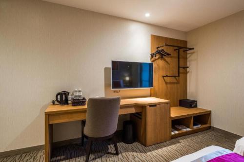 a room with a desk with a computer and a chair at Taoyuan Yuehua Hotel & Golf Club in Longtan